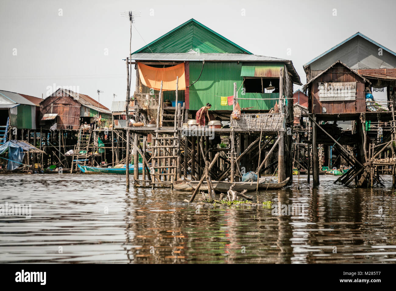 Femme sur balcon de chambre le stillts, Kampong Phluk village flottant, la Province de Siem Reap, au Cambodge. Banque D'Images