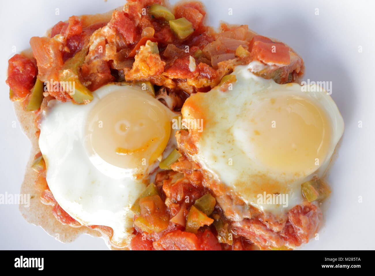 Shakshouka, un populaire plat moyen-orientale originaire de Tunisie, a fait de l'oignon, la tomate, le poivron, l'ail et les oeufs au plat avec le jaune d'ajouté l Banque D'Images