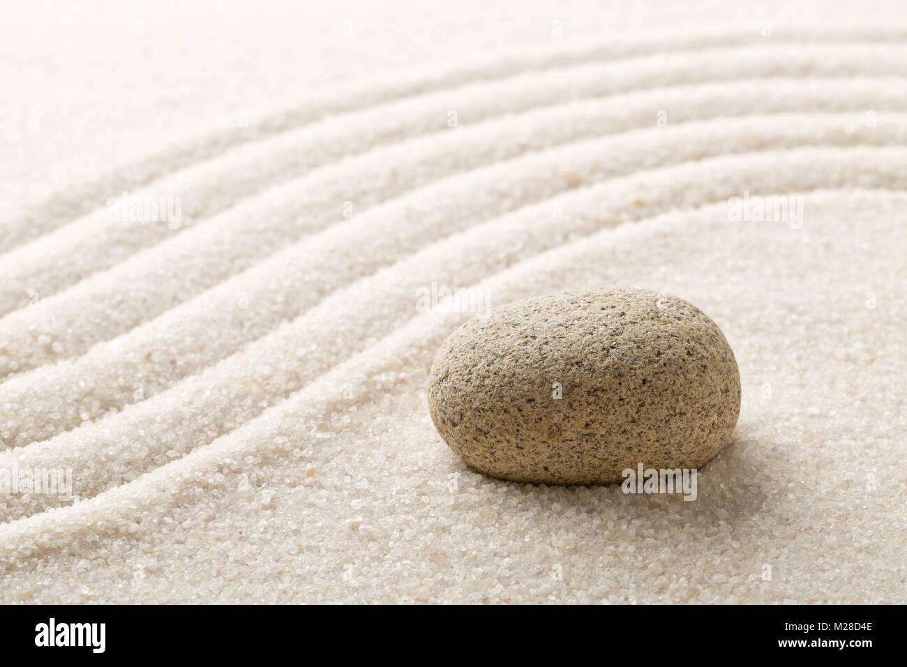 Sable et pierre jardin Zen avec des lignes courbes ratissée avec focus sélectif. La simplicité, la concentration ou le calme concept abstrait Banque D'Images