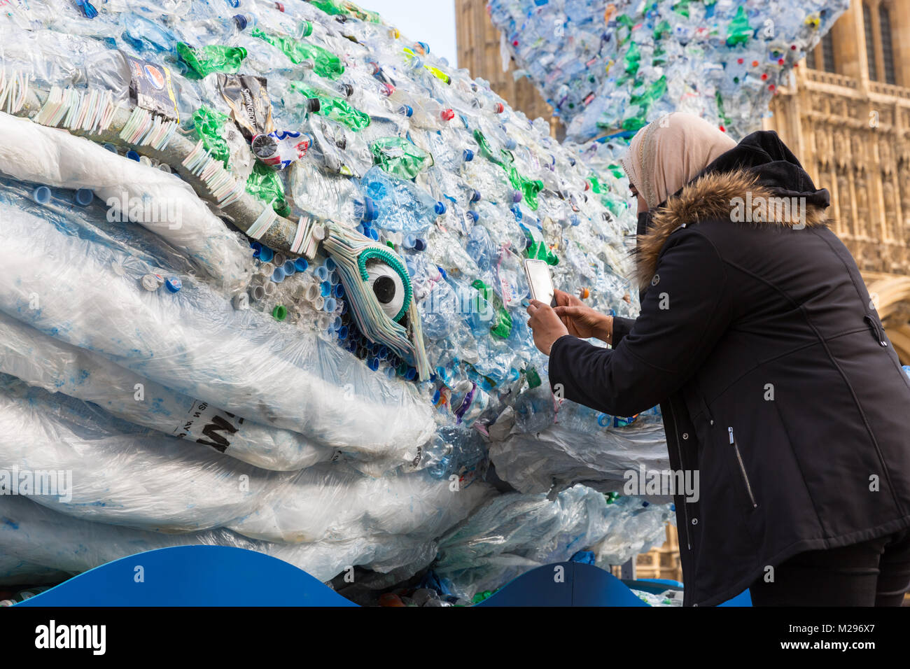 Westminster, Royaume-Uni. 6 Feb 2018. Une femme prend une photo de la baleine. Une baleine géante appelée 'Plasticus" est placé devant les Chambres du Parlement dans le cadre de sauvetage Ocean Sky's 'transmettre' campagne en plastique. La campagne tente de faire prendre conscience de la quantité de bouteilles en plastique et des déchets, pollution de l'eau et mettent en danger les animaux, y compris les baleines. 'Transmettre' en plastique s'efforce de faire une différence en remplacement des bouteilles jetables et réutilisables avec eux pour aider à sauver les océans. Credit : Imageplotter News et Sports/Alamy Live News Banque D'Images