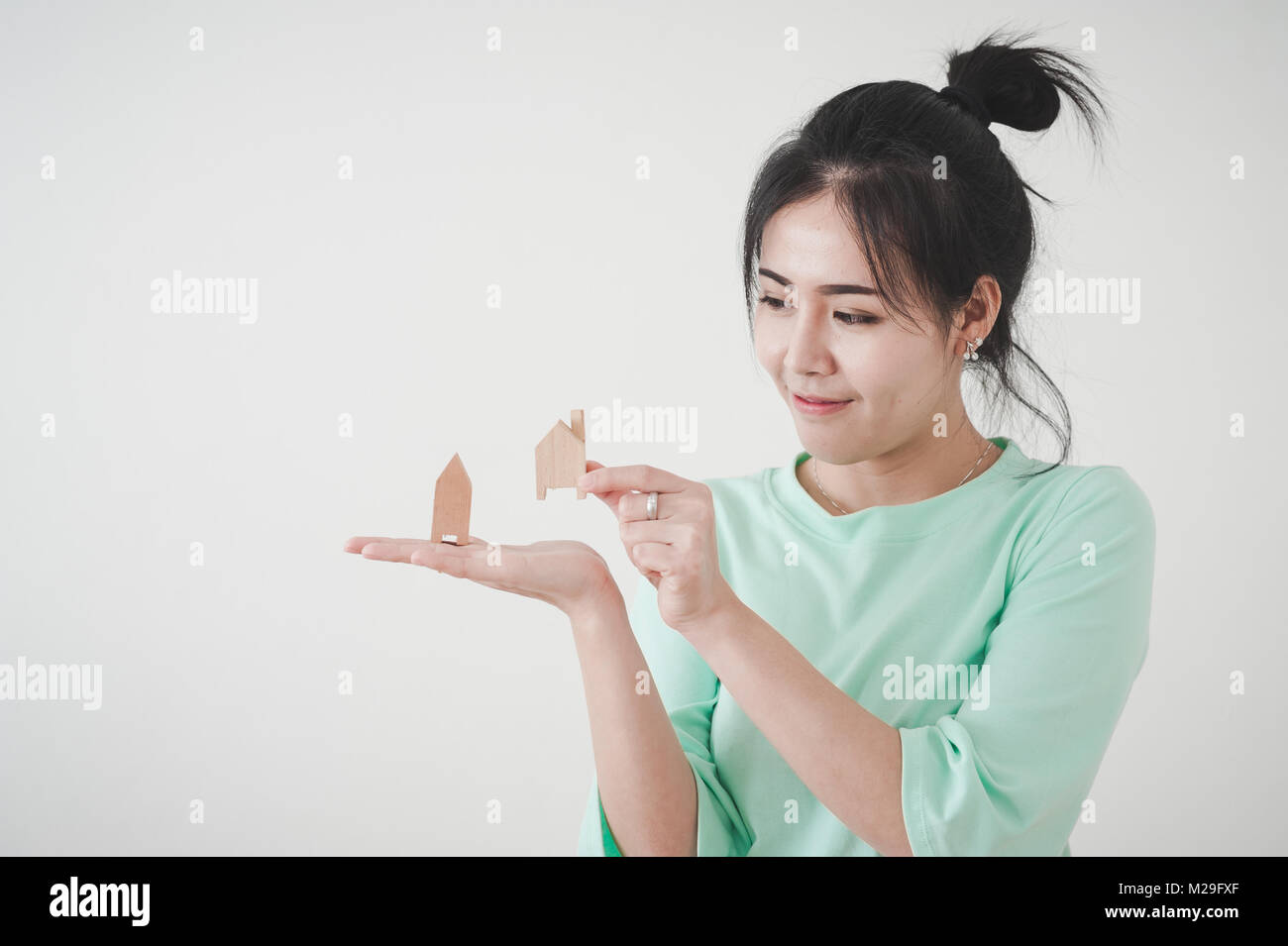 Jeune femme asiatique attrayant montrant petit modèle maison en bois dans sa main. Les affaires, la vie, la croissance et plan de rêve pour la famille concept Banque D'Images