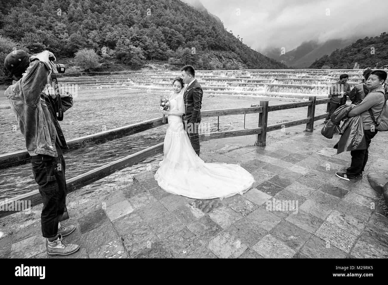 Lijiang, Chine - le 22 septembre 2017 : séance photo couple de mariage à l'eau blanc dans la rivière de la vallée de la Lune Bleue, l'une des destinations de voyage haut de la Chine Banque D'Images