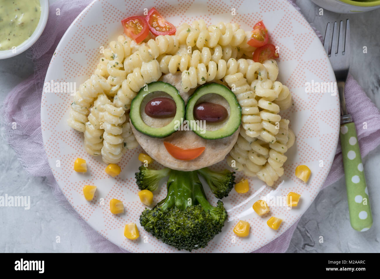 Funny Girl face à la nourriture avec l'escalope de poulet, pâtes et légumes Banque D'Images