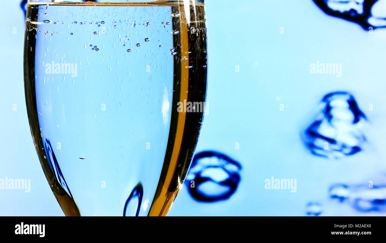 Verser de l'eau propre dans le verre sur le fond bleu Banque D'Images