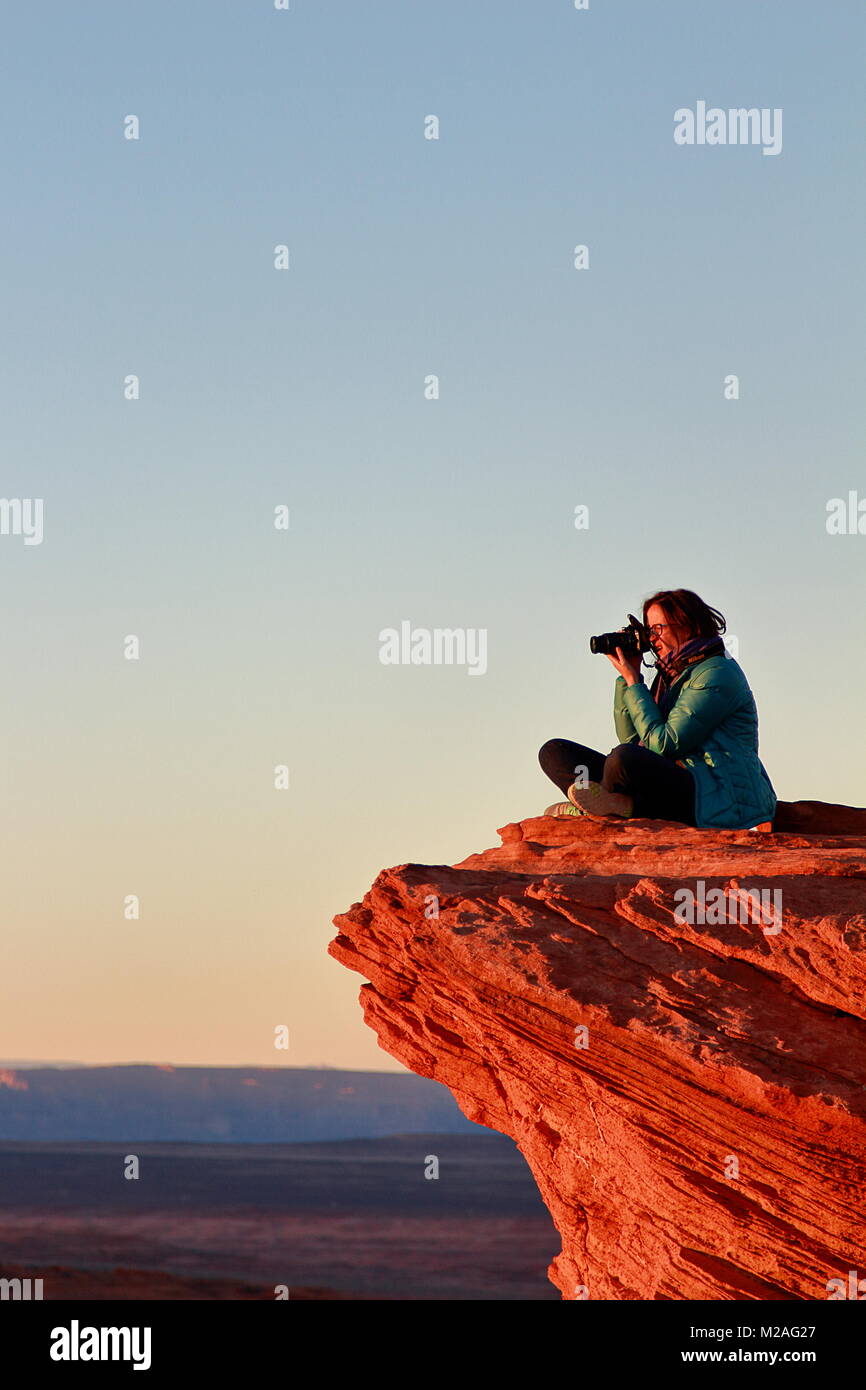 Page, Arizona - 28 décembre 2016 : Femme photographe prend des photos avec l'appareil photo grand assis sur le bord de la falaise à Horseshoe Bend Banque D'Images
