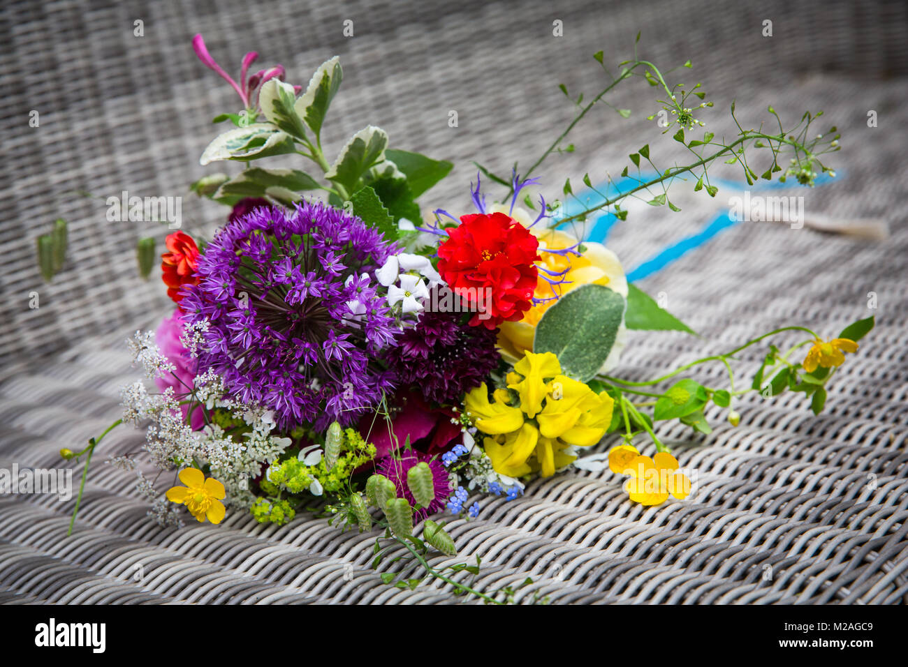 Bouquet de fleurs colorées avec allium et renoncules sur osier Banque D'Images