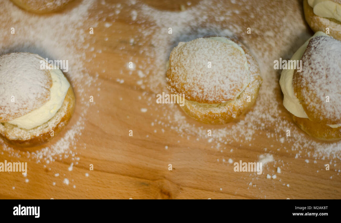 Les jours gras traditionnel bun - semla sur une planche à découper, saupoudrés de sucre. Banque D'Images