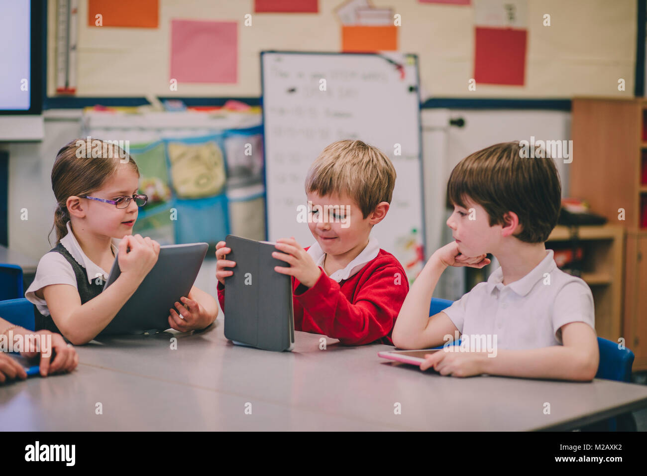 Le tableau de l'école primaire, en classe sont à l'aide de tablettes numériques pour travailler sur. Banque D'Images