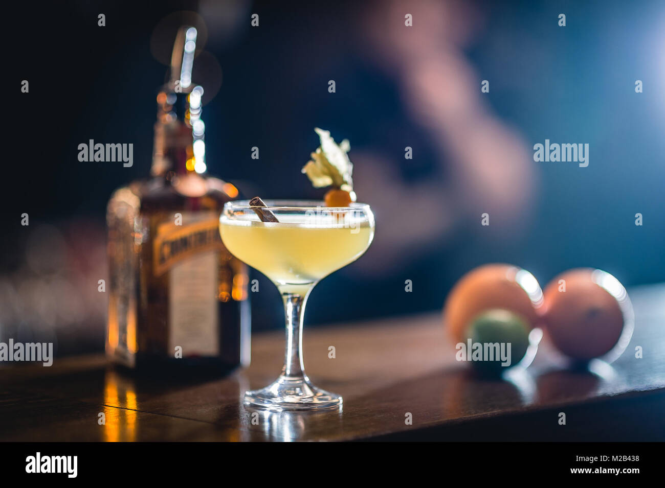L'alcool dans le verre à cocktail avec cinemon stick sur l'arrière-plan flou. Verre au bar. Banque D'Images