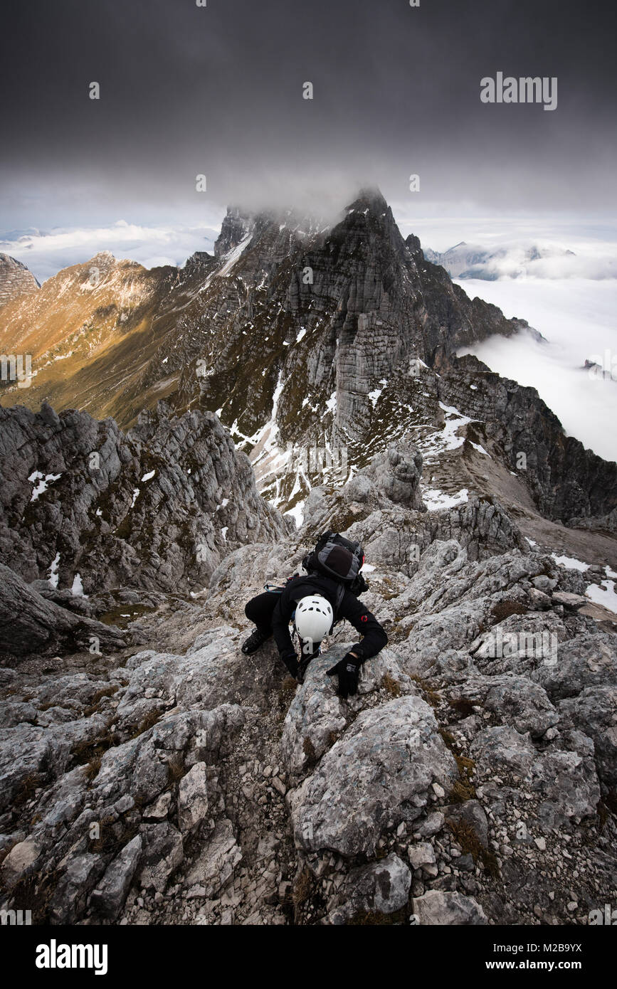 Un grimpeur à descendre la montagne, d'essayer d'être assez rapide pour éviter l'approche de l'orage. L'un tu ne veux pas salir avec à 2500m dans les Alpes. Banque D'Images