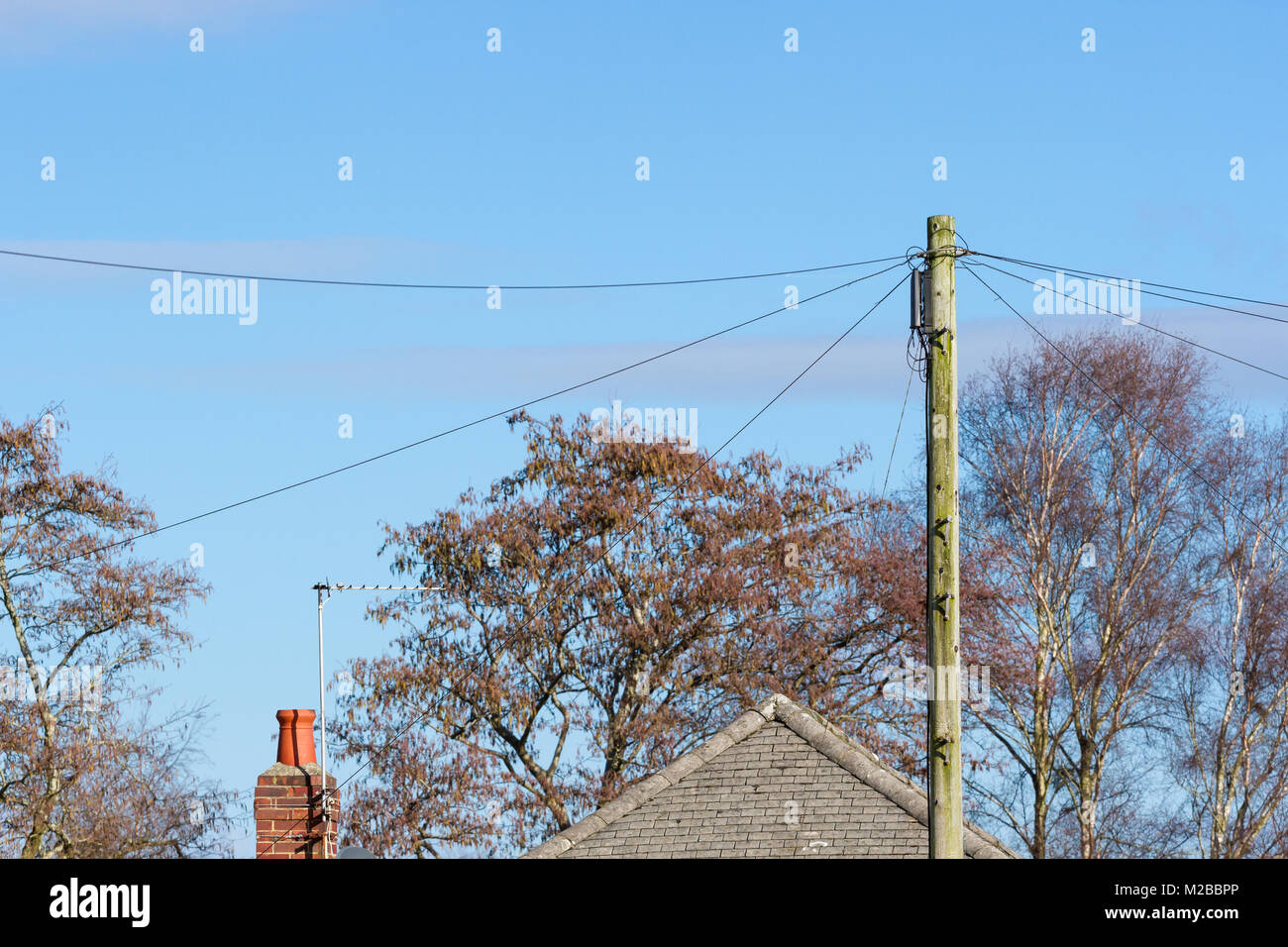 Le sommet d'un poteau de téléphone avec lignes de téléphone connecté dans un quartier résidentiel. United Kingdom Banque D'Images