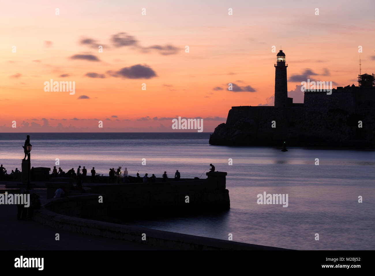 Castillo de los Tres Reyes Magos del Morro et Faro Castillo del Morro phare et des gens assis le long de la digue à l'entrée du port. Banque D'Images