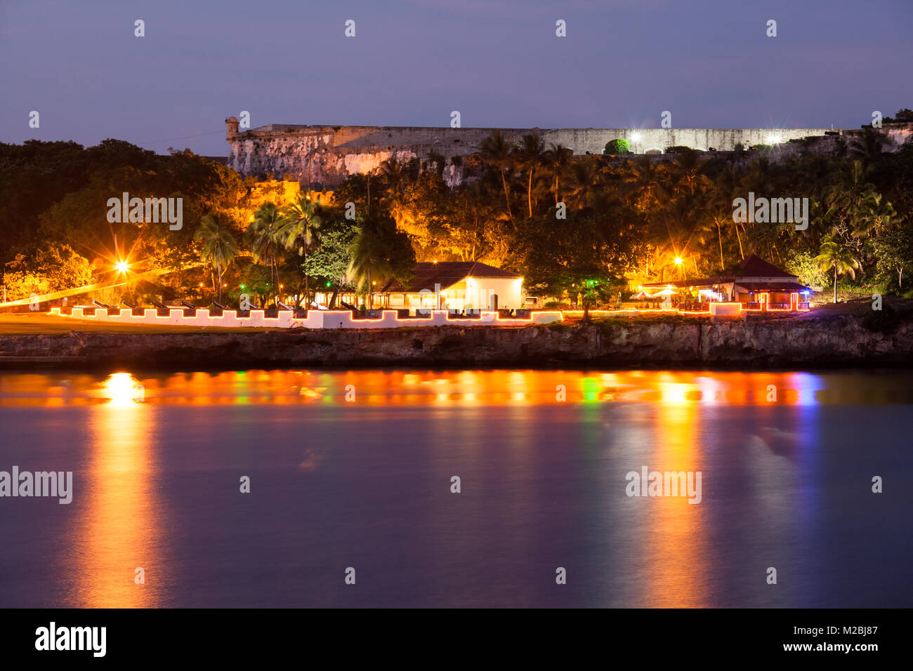 Restaurants et Fortaleza de San Carlos de la Cabaña illuminée la nuit sur la baie de La Havane à Casablanca, La Havane, Cuba. Banque D'Images