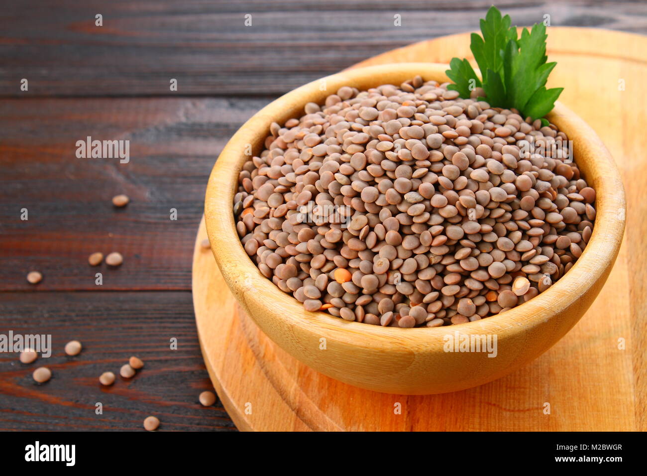 Les lentilles rouges dans un bol en bois sur une table en bois Banque D'Images
