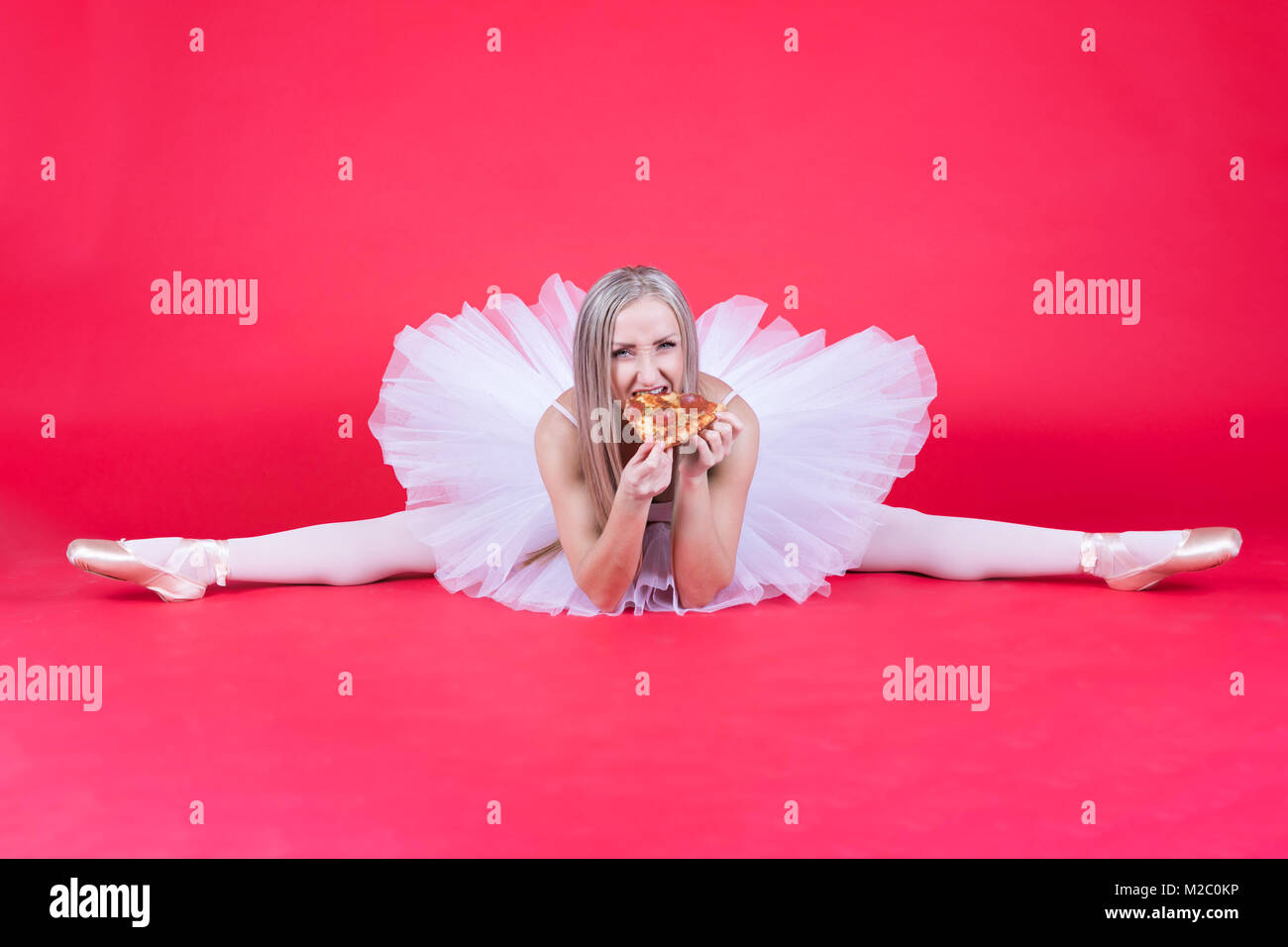 Ballerine blonde assis dans un groupe et de manger une pizza slice sur fond  rouge Photo Stock - Alamy