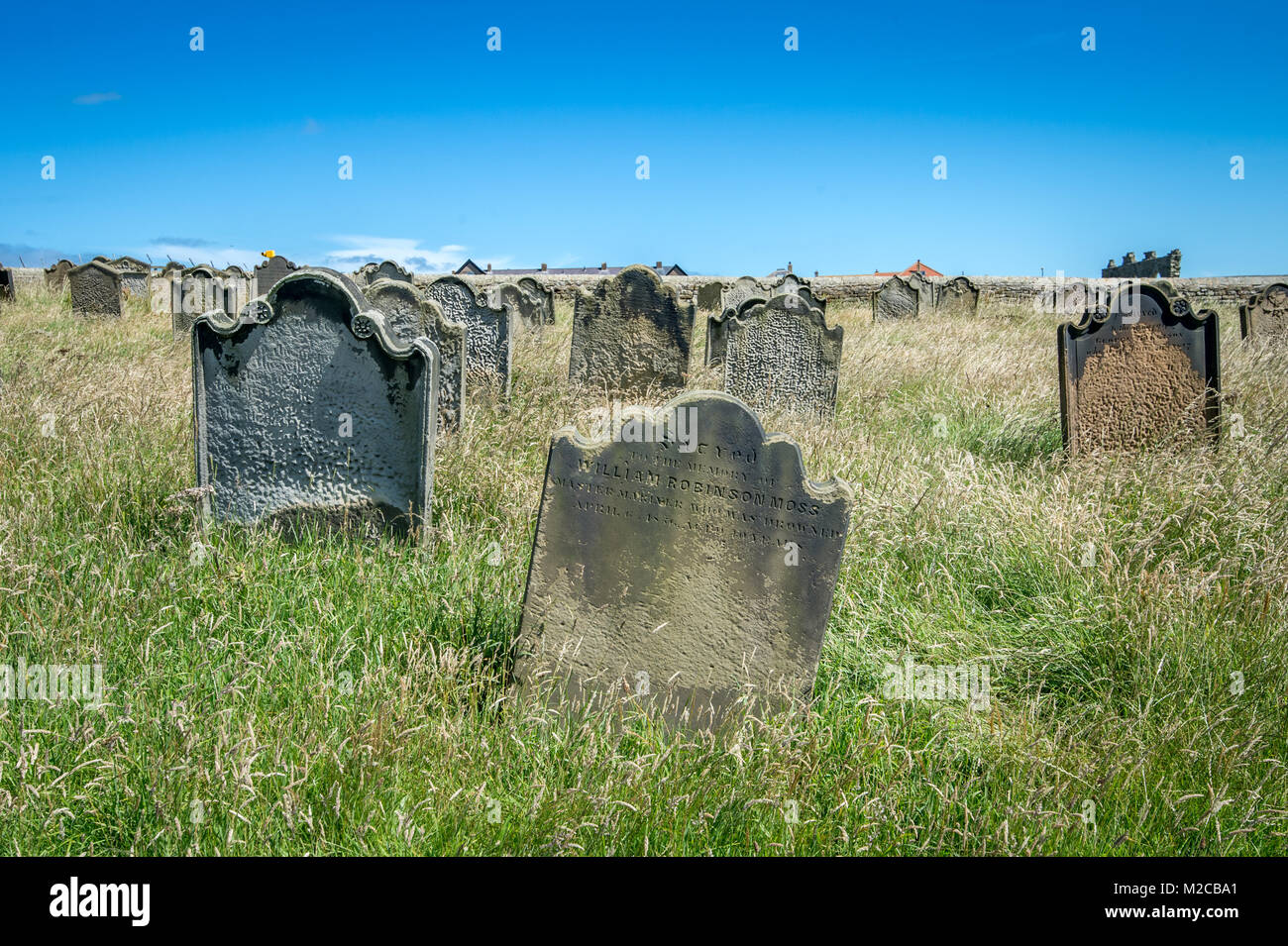 Des pierres tombales surmonté de pics hautes herbes, Whitby, dans le Yorkshire, UK Banque D'Images