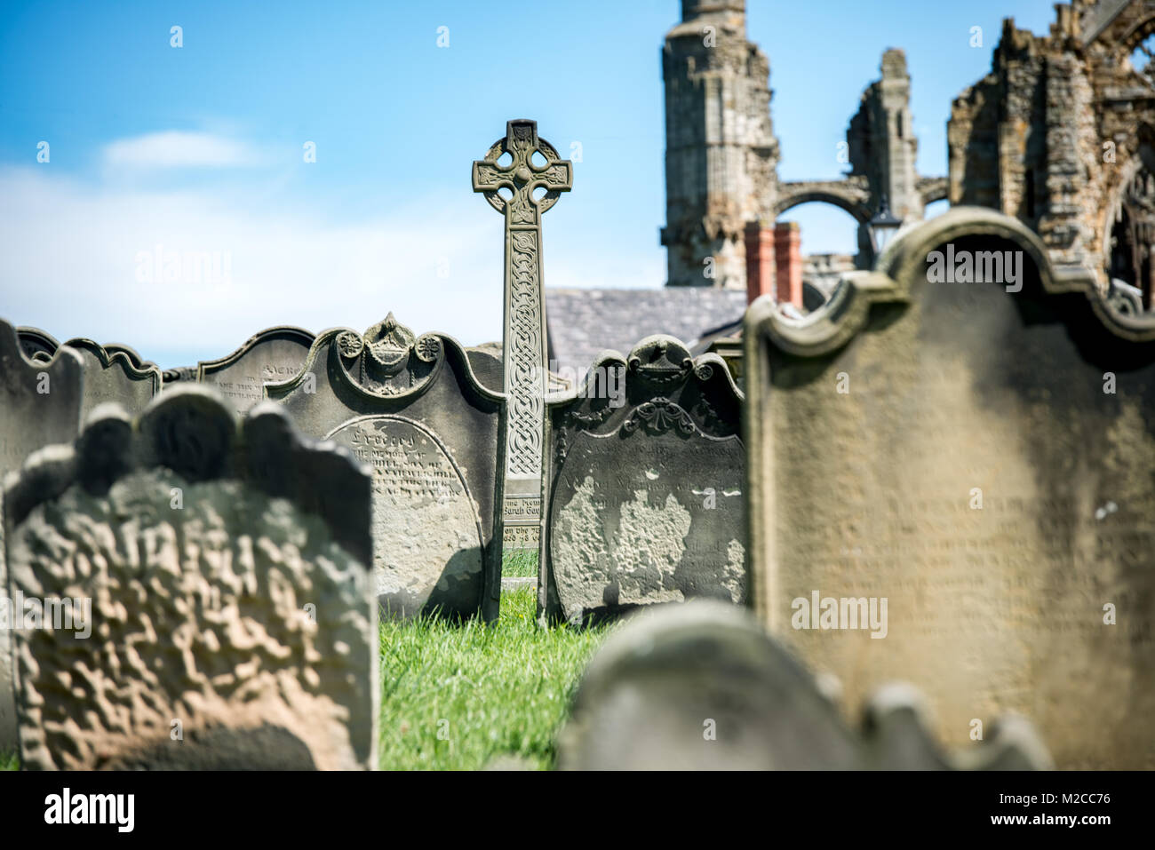 Serrés les pierres tombales contre un ciel bleu, Whitby, Yorkshire, UK Banque D'Images