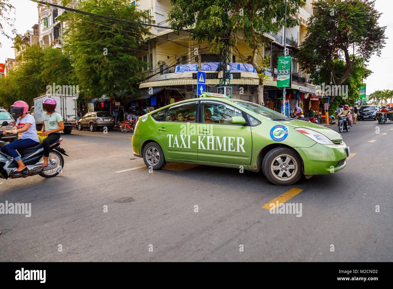 Taxi-Khmer vert moderne local traversant une route achalandée à Phnom Penh, capitale du Cambodge, au sud-est de l'Asie Banque D'Images