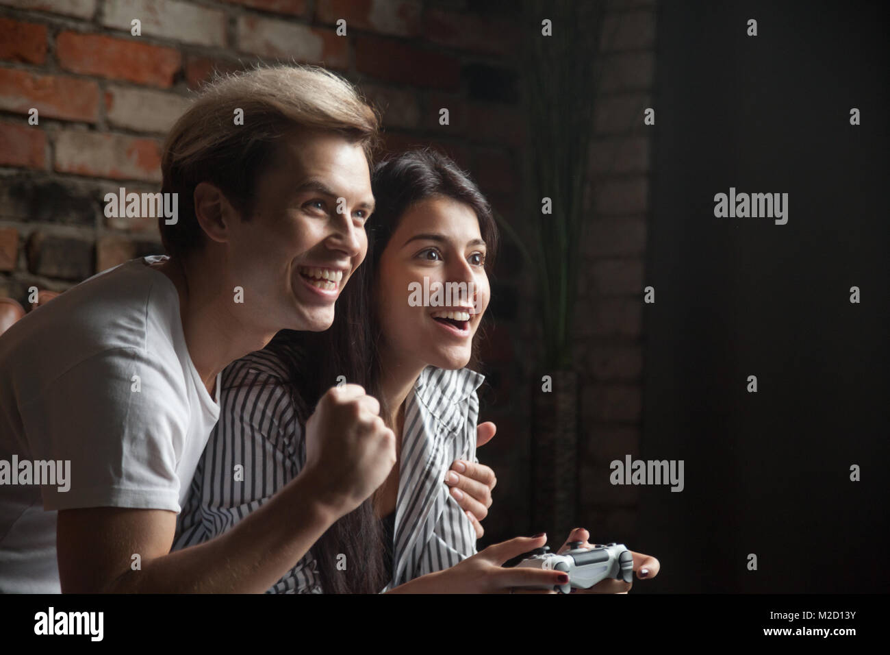 Girl gamer gagner jeu vidéo avec l'aide de petit ami Banque D'Images