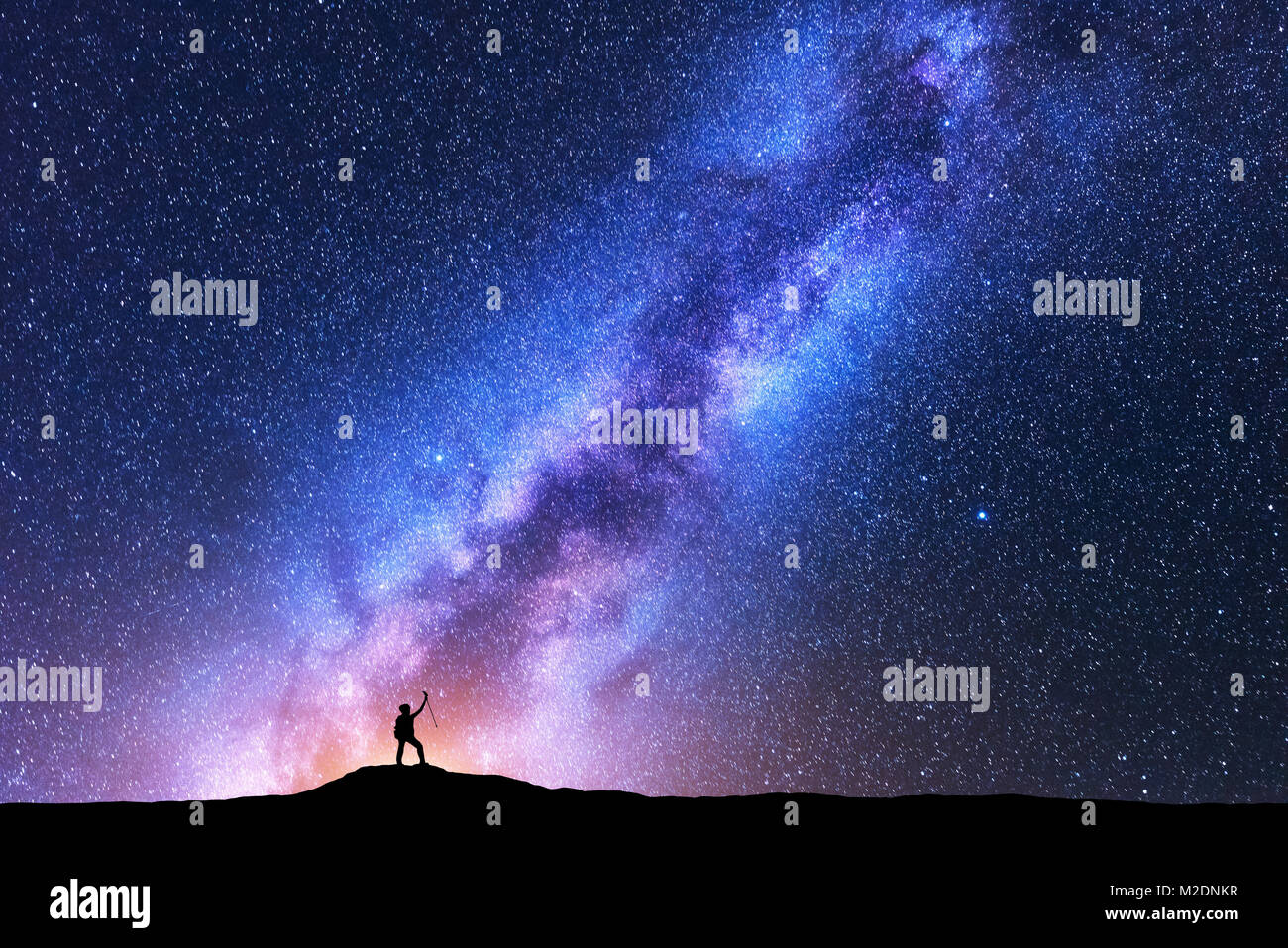 Silhouette de femme heureuse avec des bâtons de marche contre la Voie Lactée la nuit. Arrière-plan de l'espace. Paysage avec la fille sur la montagne, clair voie lactée w Banque D'Images