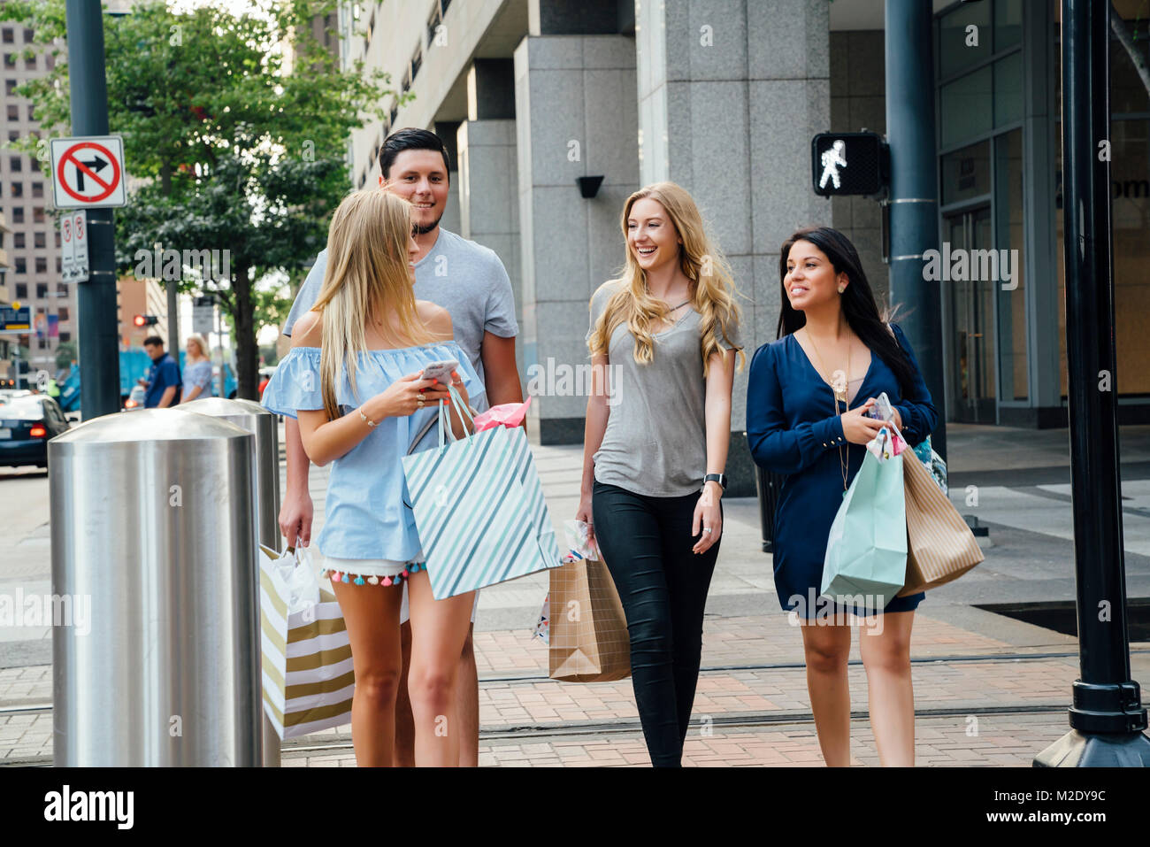 Amis marchant en ville shopping des SMS sur les téléphones portables Banque D'Images