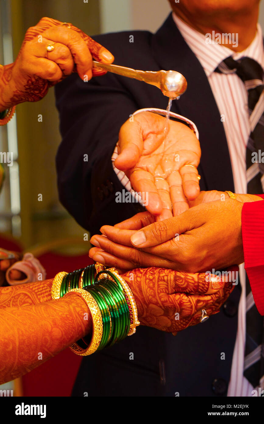 Rituel traditionnel de mariage hindou où l'eau est faite à l'écoulement des mains de mariée et le marié avec le père de la mariée Banque D'Images