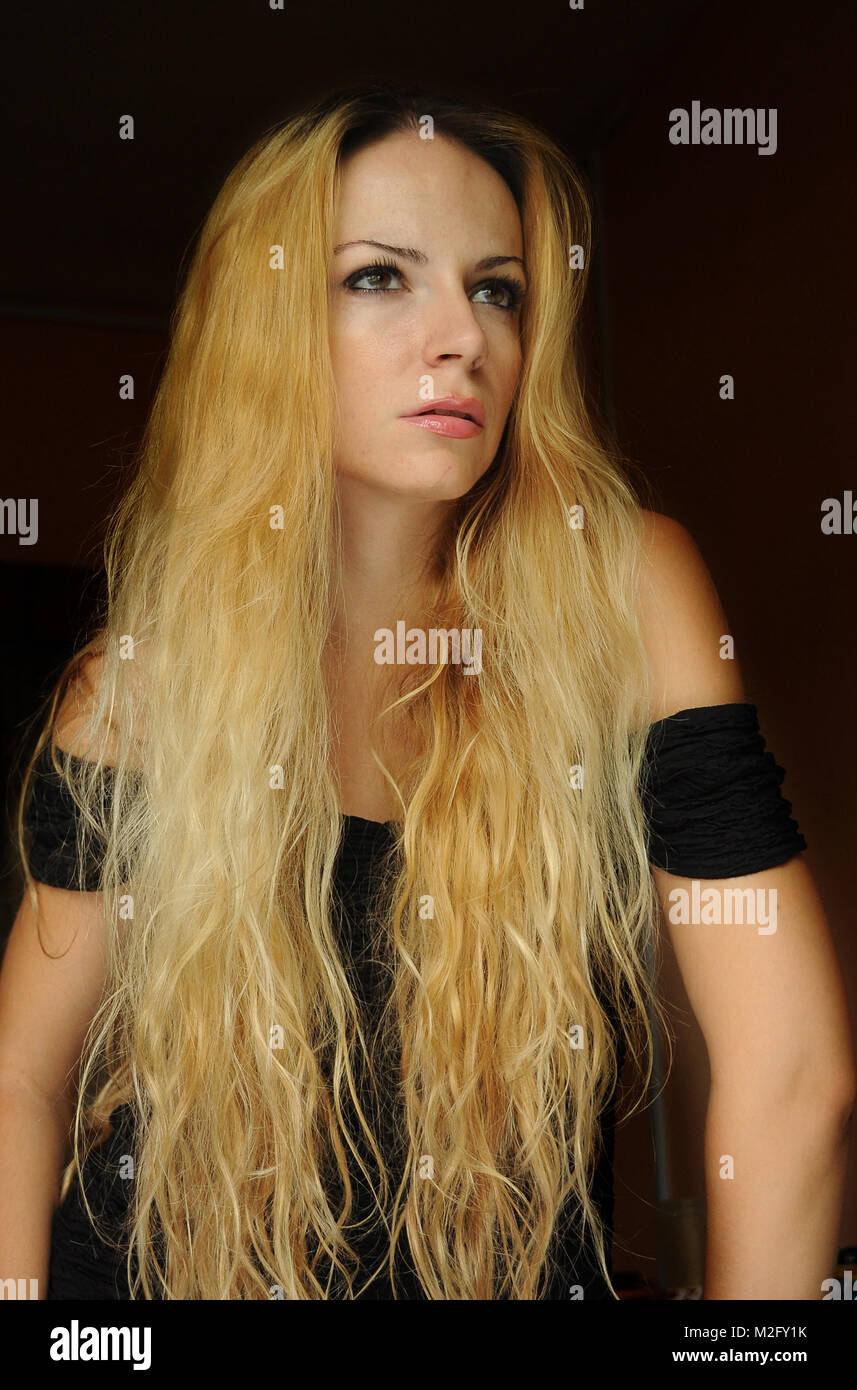 Jeune femme avec de longs cheveux blonds ondulés Banque D'Images