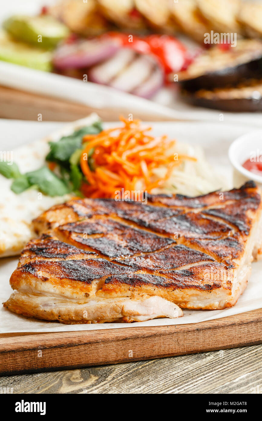 Grill Steak de porc. Servir sur une planche en bois sur une table rustique. Restaurant Barbecue menu, une série de photos de différentes viandes Banque D'Images