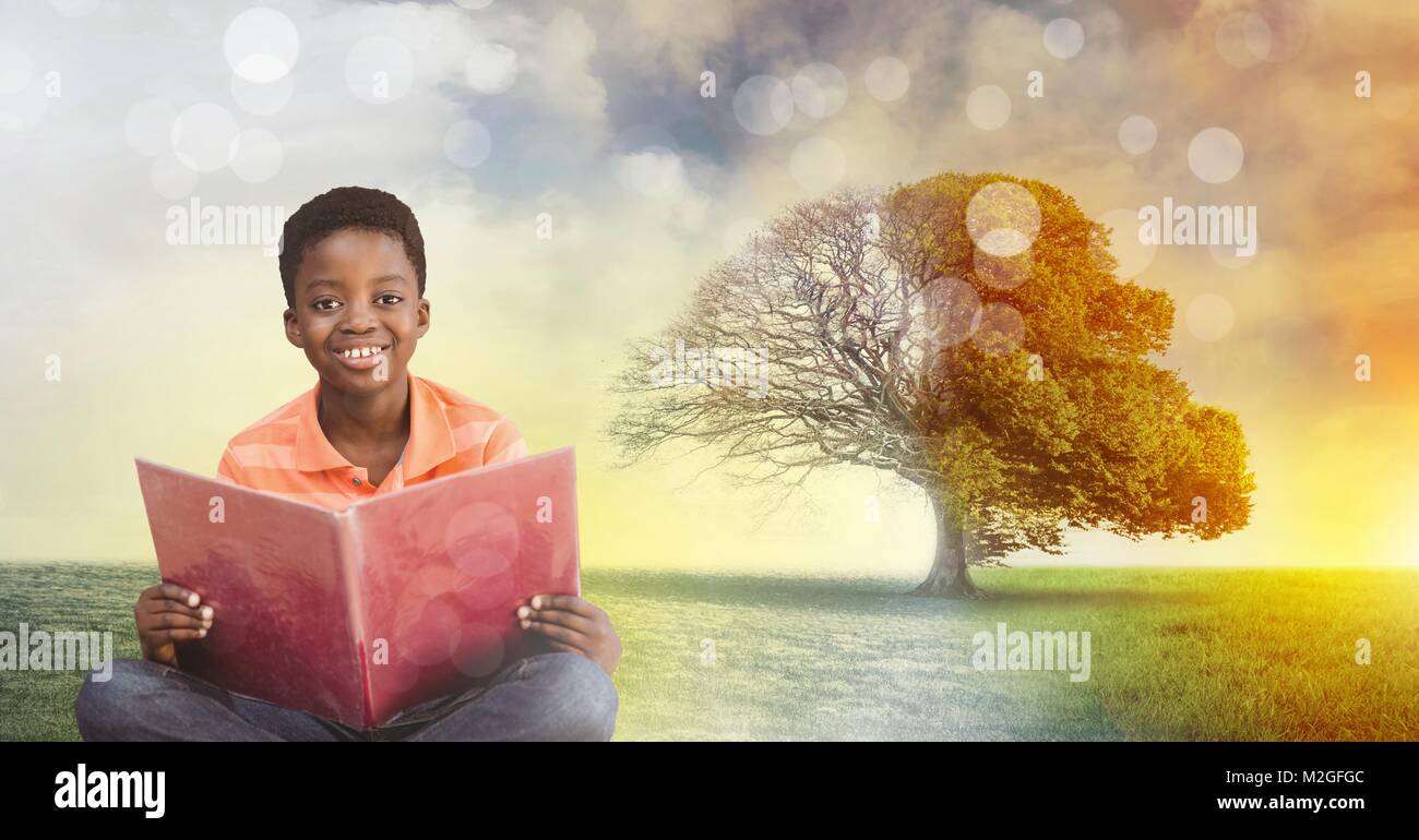 Boy holding livre avec imagination surréaliste saisonniers arbre magique Banque D'Images