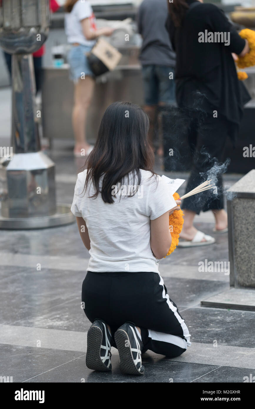 Des fidèles prient dans Trimurti Shrine (dieu de l'amour) rue temple de Ratchadamri Road, Bangkok, Thaïlande Banque D'Images