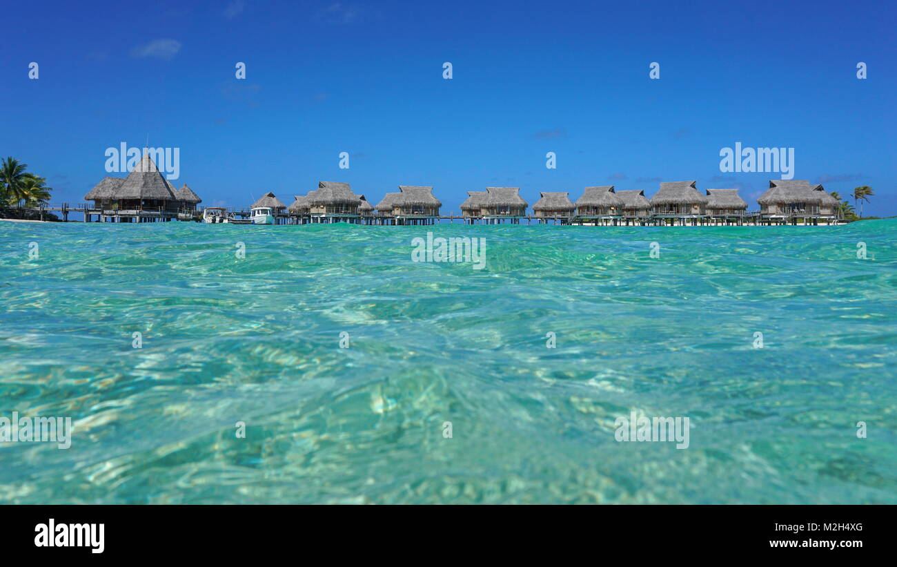 Tropical resort avec des bungalows au toit de chaume dans le lagon vu de surface de la mer, l'atoll de Tikehau, Tuamotu, Polynésie Française, océan Pacifique, Océanie Banque D'Images