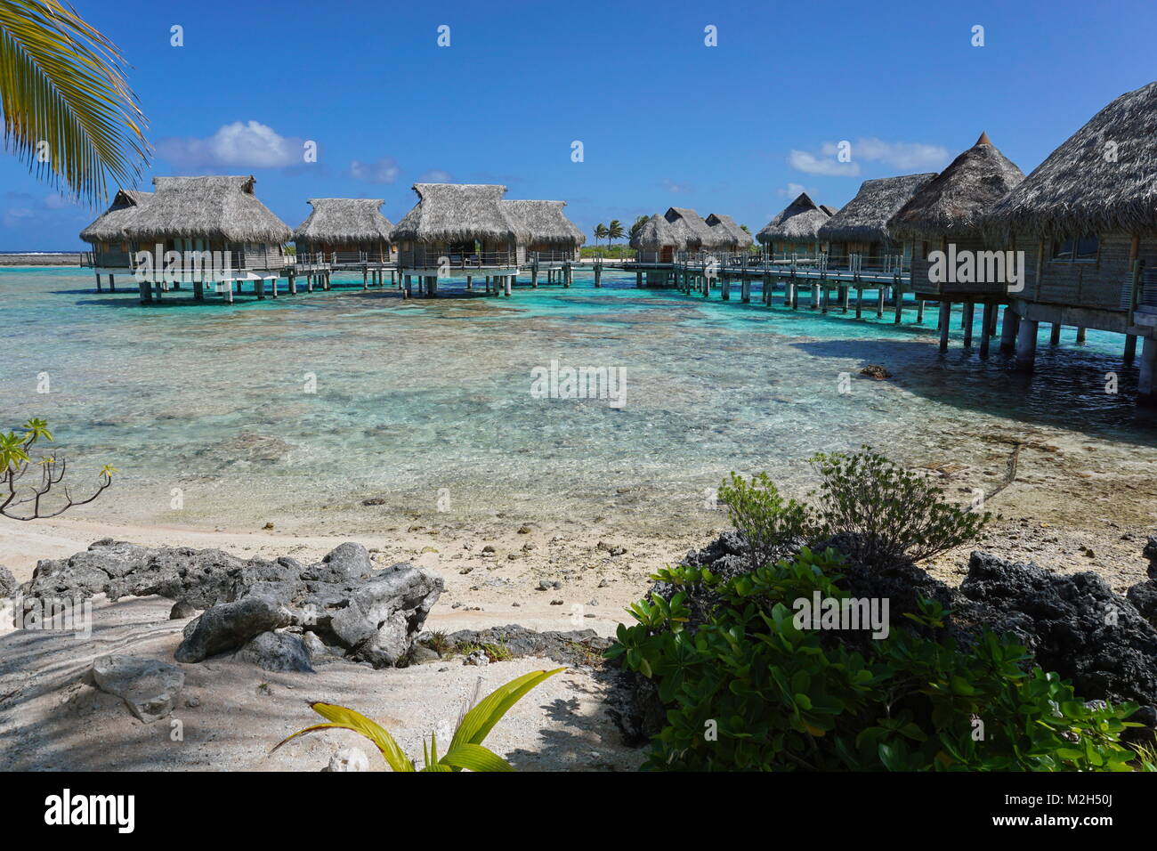 Tropical Island resort avec des bungalows sur pilotis dans le lagon, l'atoll de Tikehau, Tuamotu, Polynésie Française, océan Pacifique, Océanie Banque D'Images