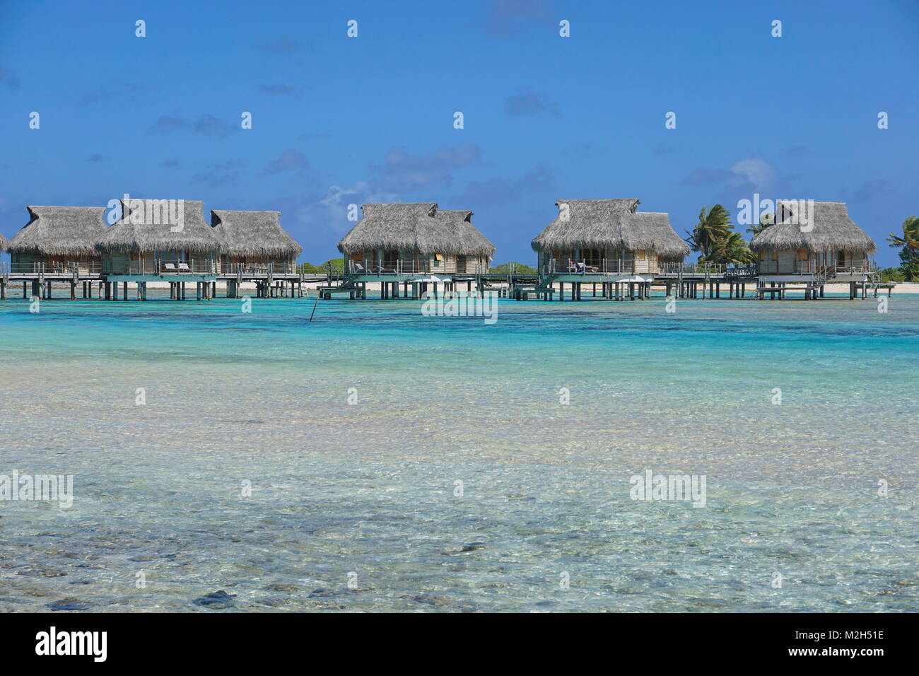 Tropical resort avec des bungalows sur pilotis dans le lagon, l'atoll de Tikehau, Tuamotu, Polynésie Française, océan Pacifique, Océanie Banque D'Images