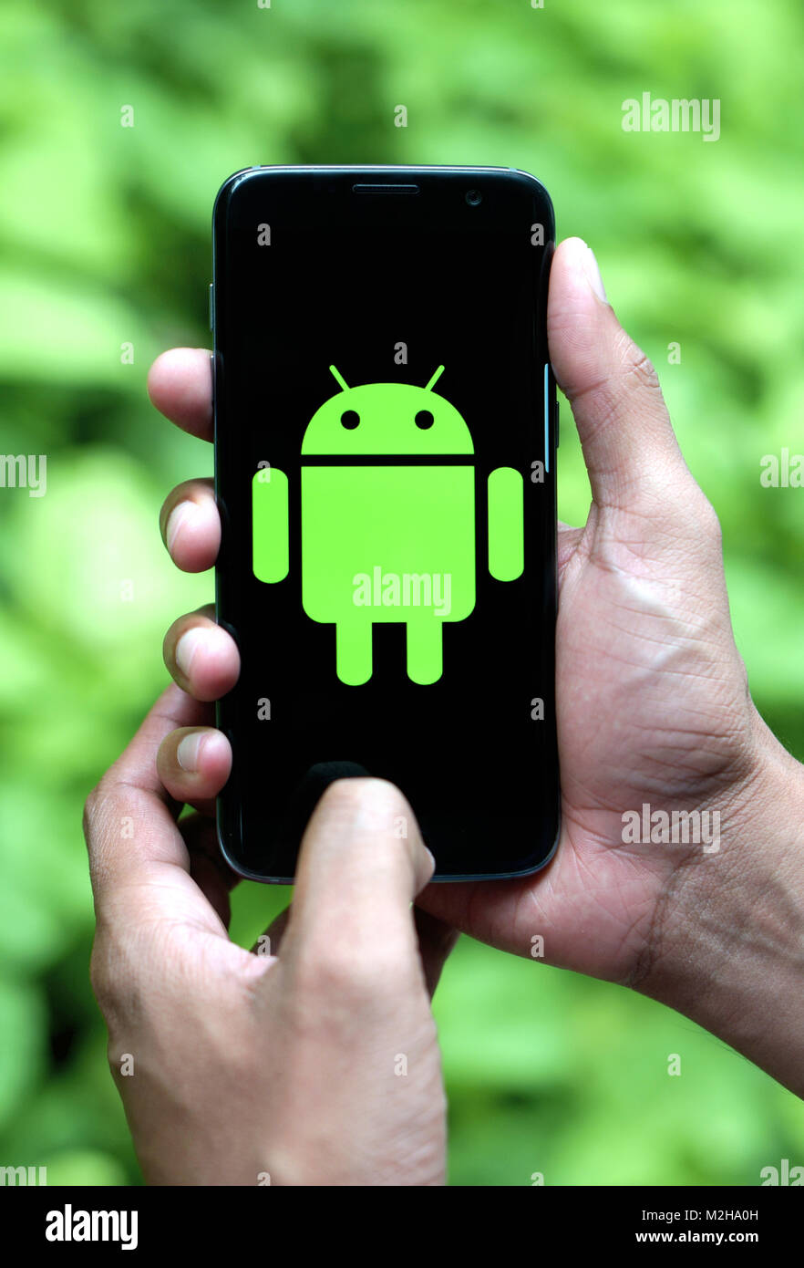 Man holding mobile Android avec logo Banque D'Images