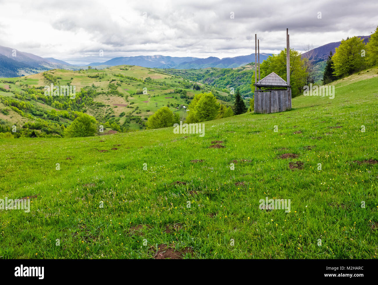 Vieux bois hay shed on grassy hillside. beaux paysages des montagnes de l'espace rural au printemps Banque D'Images