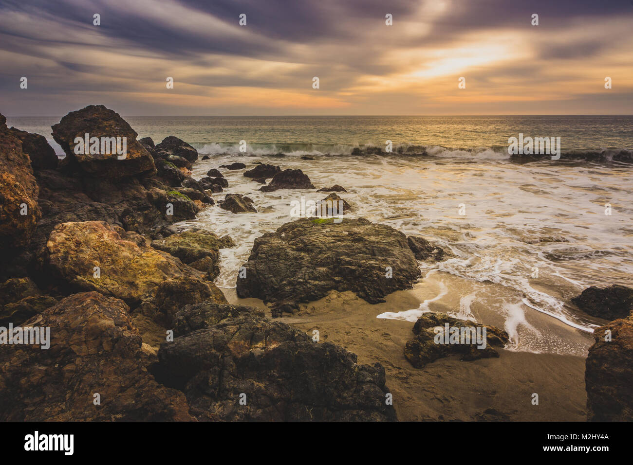 Ciel magnifique après le coucher du soleil le long de Point Dume State Beach avec des vagues se briser dans des formations rocheuses le long de la plage, Malibu, Californie Banque D'Images