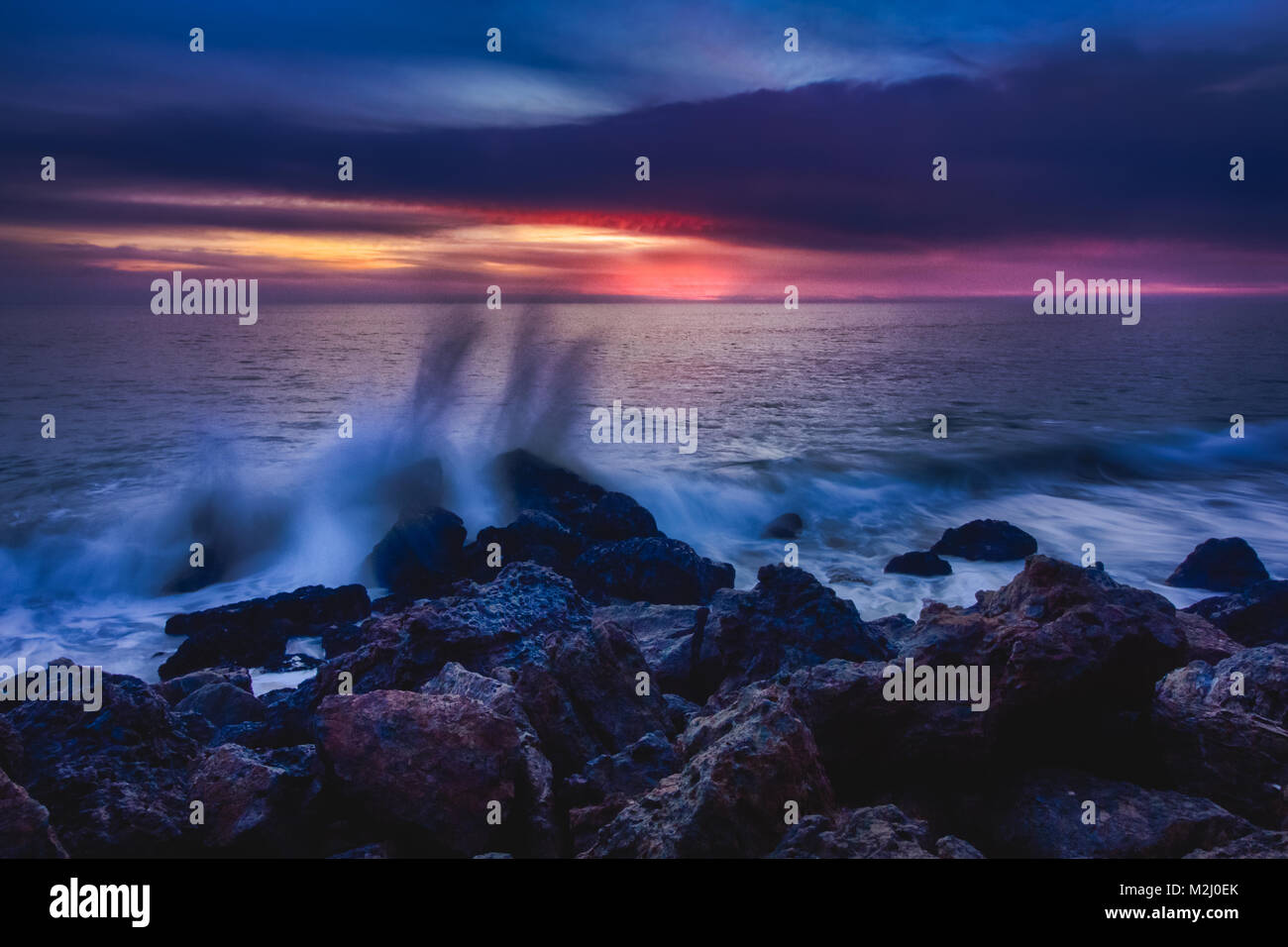 Ciel magnifique après le coucher du soleil le long de Point Dume State Beach avec des vagues se briser dans des formations rocheuses le long de la plage, Malibu, Californie Banque D'Images