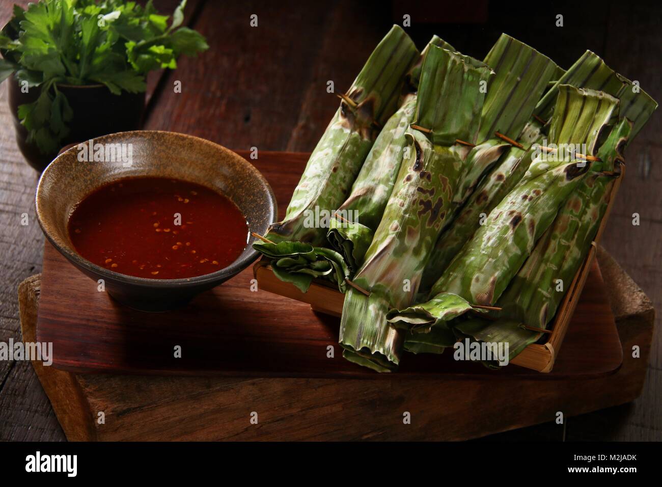 Otak otak de Palembang, les grillades de poissons dans des feuilles de banane Gâteau Colis, servi avec sauce au vinaigre épicé Banque D'Images