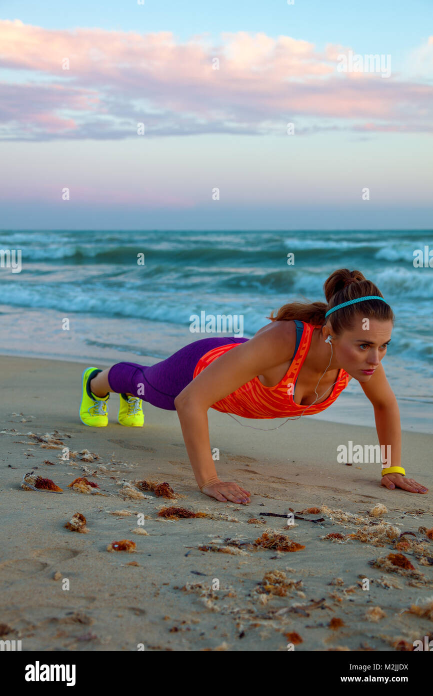 Côté mer sauvage rafraîchissante. entraînement femme active dans les  vêtements de sport sur le bord de mer au coucher du soleil faisant pushups  Photo Stock - Alamy