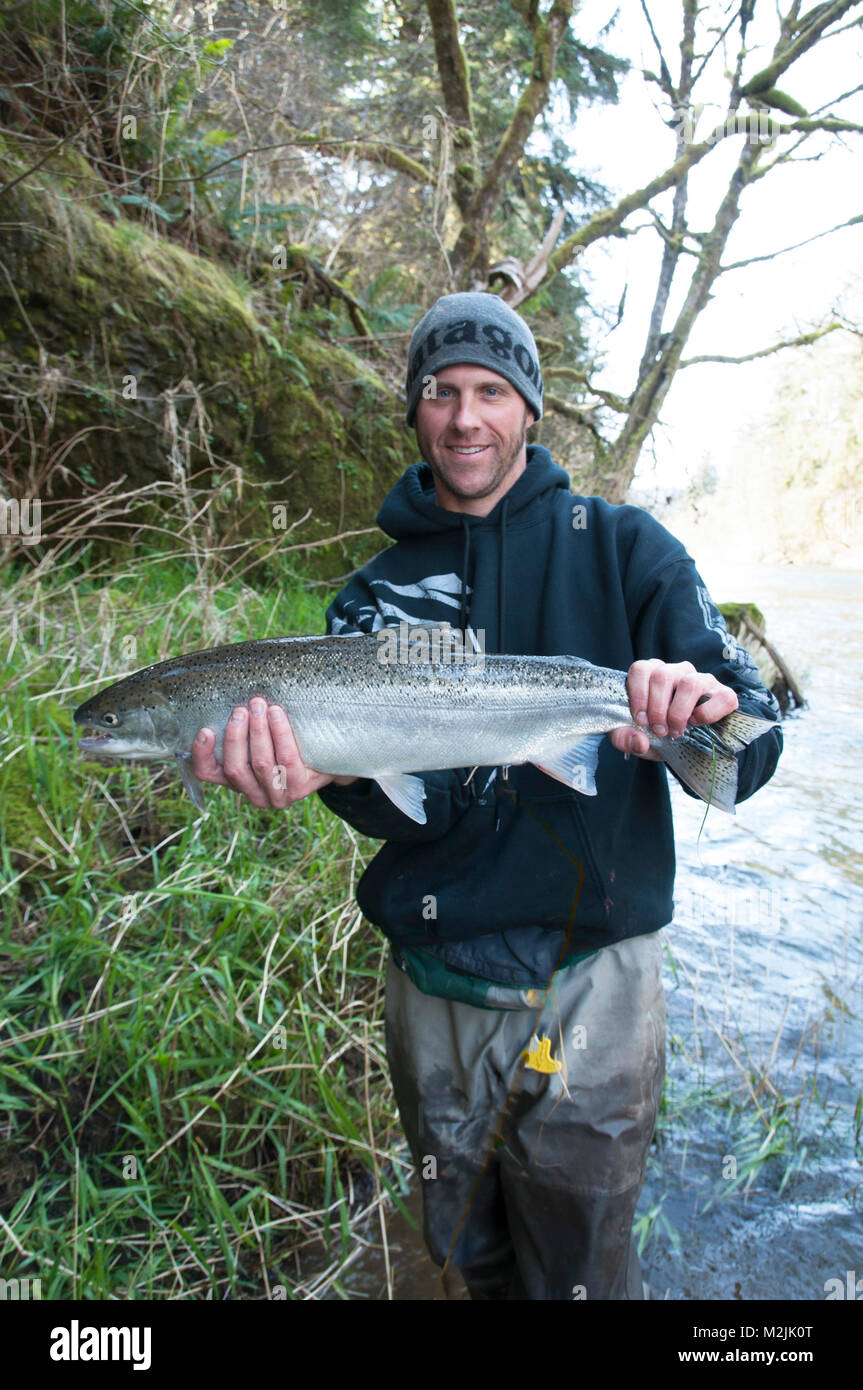 Les pêcheurs de truites arc-en-ciel avec un arc-en-ciel de la rivière Siletz produites en écloserie capturés sur un flotteur guidée voyage. Modèles de publication, d'édition seulement. Banque D'Images