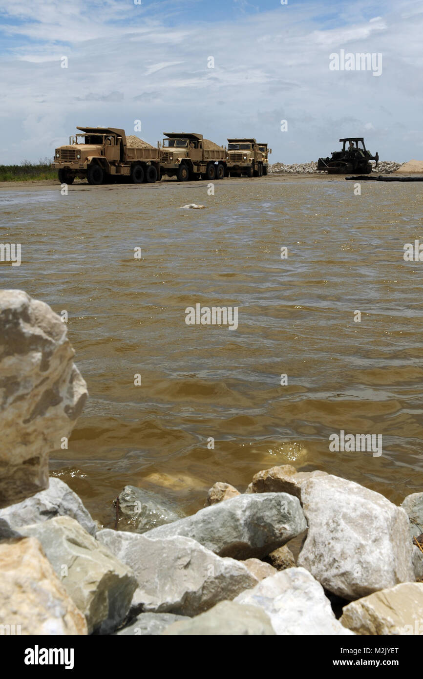 GRAND ISLE, en Louisiane - Les soldats de l'Armée de la Garde nationale de la Louisiane 844e compagnie du génie se préparent à renforcer un mur de pierre avec un tissu géotextile recouvert de sable sur l'Île à Grand Isle Elmers, LA le 6 juillet 2010 à l'appui de l'horizon profond nettoyage en cas de déversement d'efforts. Une toile géotextile perméable est une matière textile utilisé pour augmenter la stabilité du sol, fournir de l'érosion ou l'aide dans le drainage. (U.S. Photo de l'Armée de l'air par le sergent. Jeffrey T. Barone) mur de roche 072 gardes renforcer par la Garde nationale de la Louisiane Banque D'Images