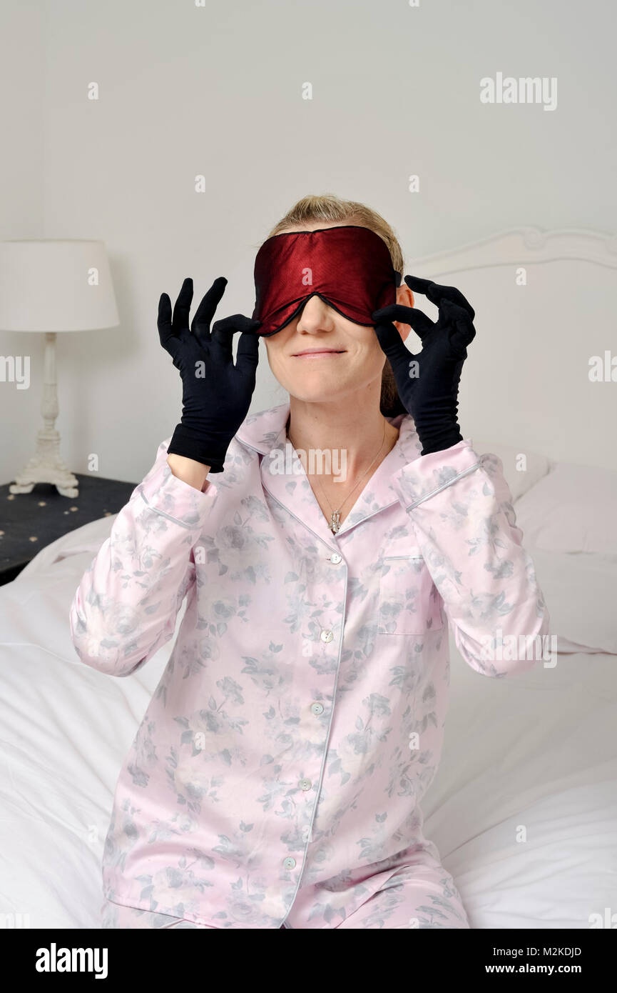 Femme dans sa chambre à coucher à l'aide de soins de beauté avant qu'elle dort. Banque D'Images