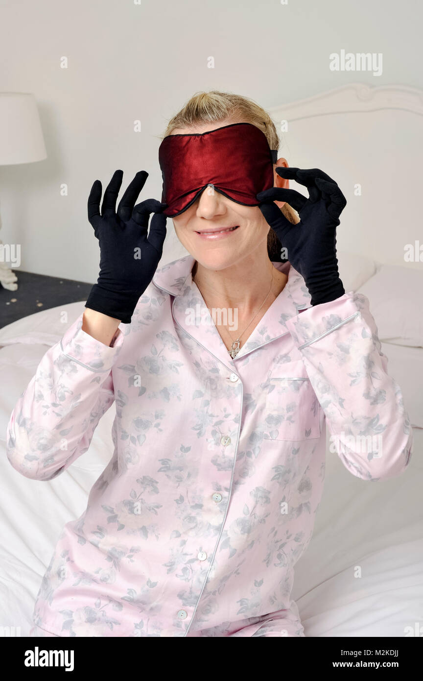 Femme dans sa chambre à coucher à l'aide de soins de beauté avant qu'elle dort. Banque D'Images
