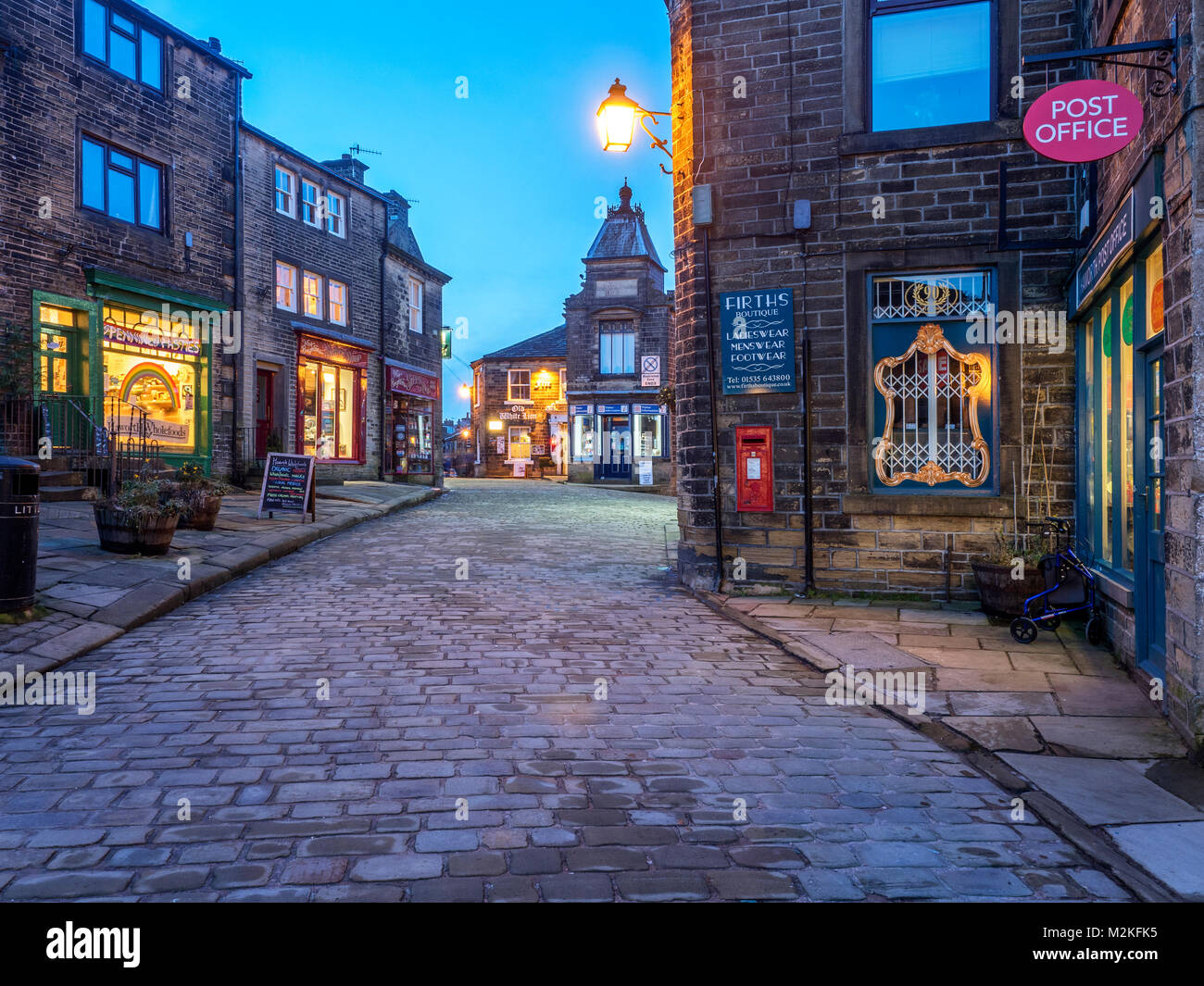Des voyants le long de la rue principale pavée de Haworth Village à la tombée de la West Yorkshire Angleterre Banque D'Images