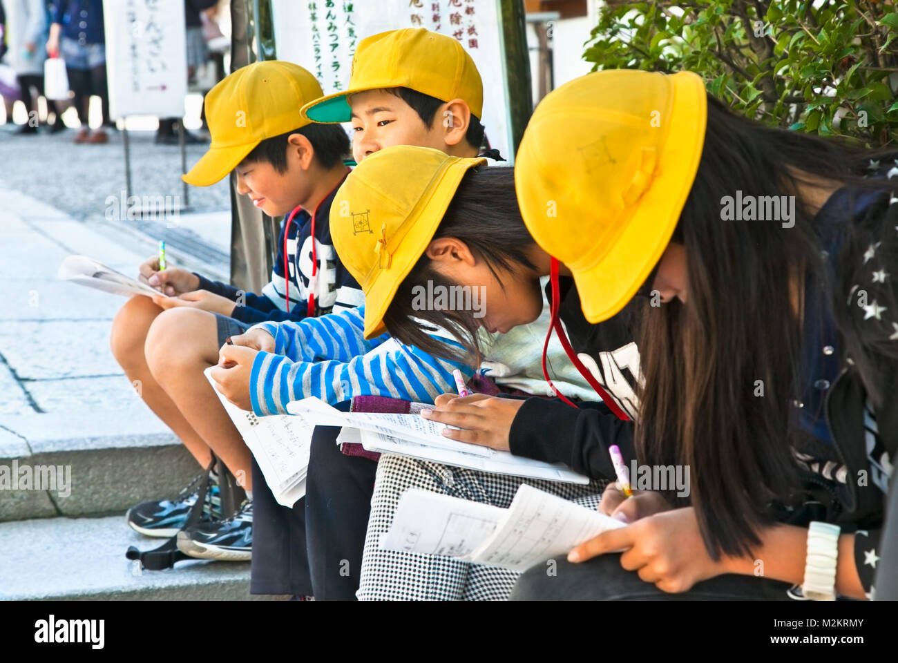 KYOTO, JAPON-OCT 24,2014 : enfants de l'école japonaise avec les capuchons jaunes font leurs devoirs dans la rue de Kyoto le Oct 24, 2014, au Japon. Banque D'Images