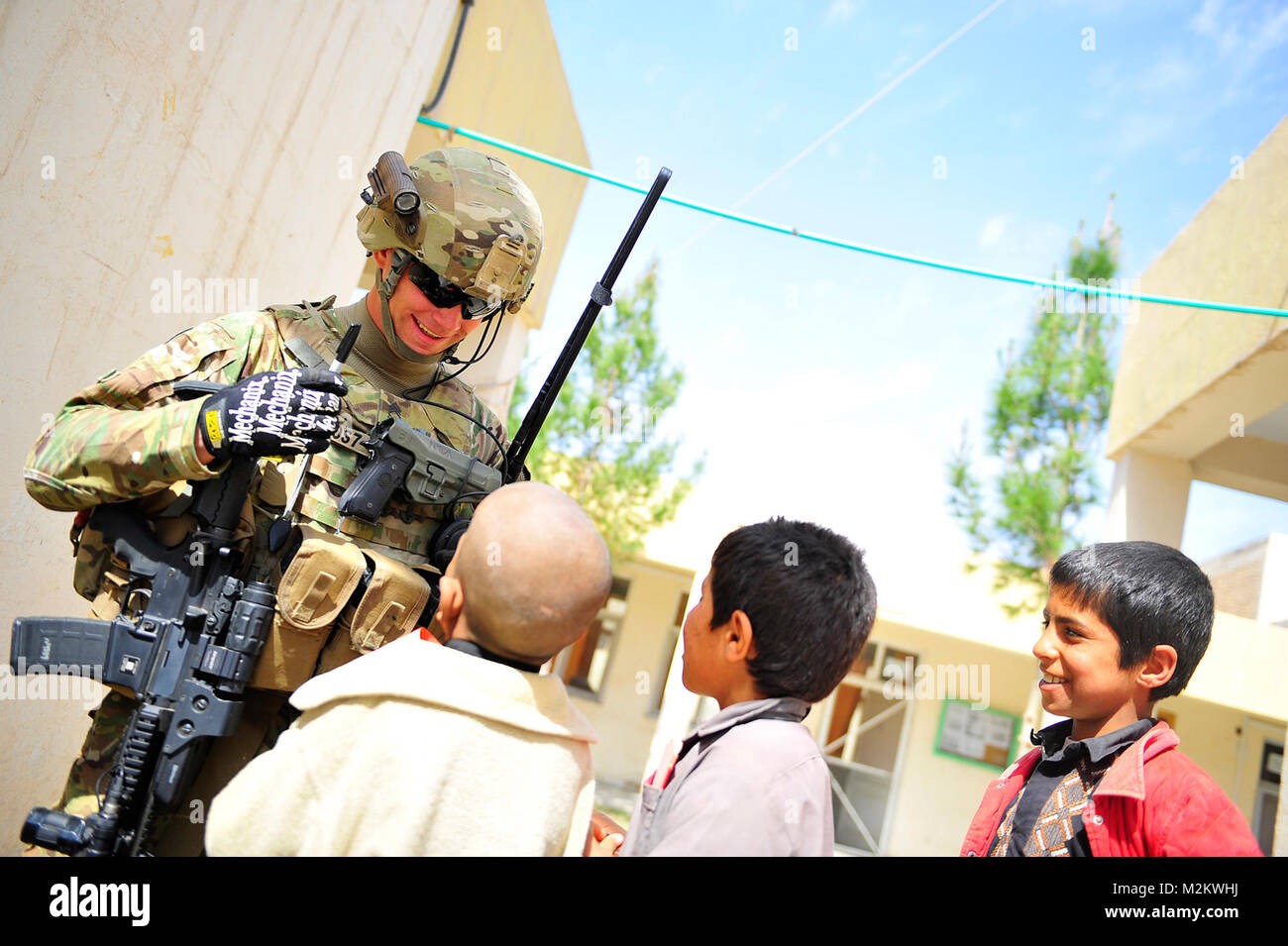 U.S. Army National Guard Le Sergent de 1re classe Michael Nelson, le sergent du peloton de la Force de sécurité (SECFOR) élément d'Équipe provinciale de reconstruction (EPR) Farah, passe du temps avec les enfants au cours d'une cérémonie de commémoration de la mise à niveau de l'hôpital de Farah un hôpital de district d'une province au moyen d'un gouvernement a fourni ensemble étendu de services de santé (EPH) dans la province de Farah, de la ville de Farah, l'Afghanistan le 10 mars 2012. La mise à niveau de l'hôpital fournit un budget plus important pour les fournitures médicales et l'équipement. PRT Farah est une unité de soldats, marins et aviateurs canadiens travaillant avec divers g Banque D'Images