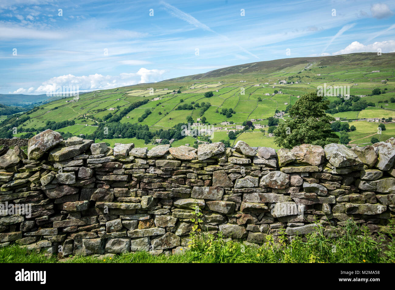 Supports muraux à la main en premier plan en face de collines vertes, Yorkshire, UK Banque D'Images