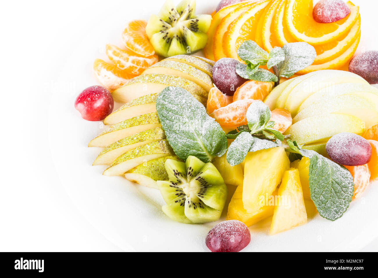 Plateau à fruits, isolé. Apple, mandarine, kiwi, raisin, menthe, poire, pomme, ananas. Salade de fruits dans la plaque, close-up Banque D'Images