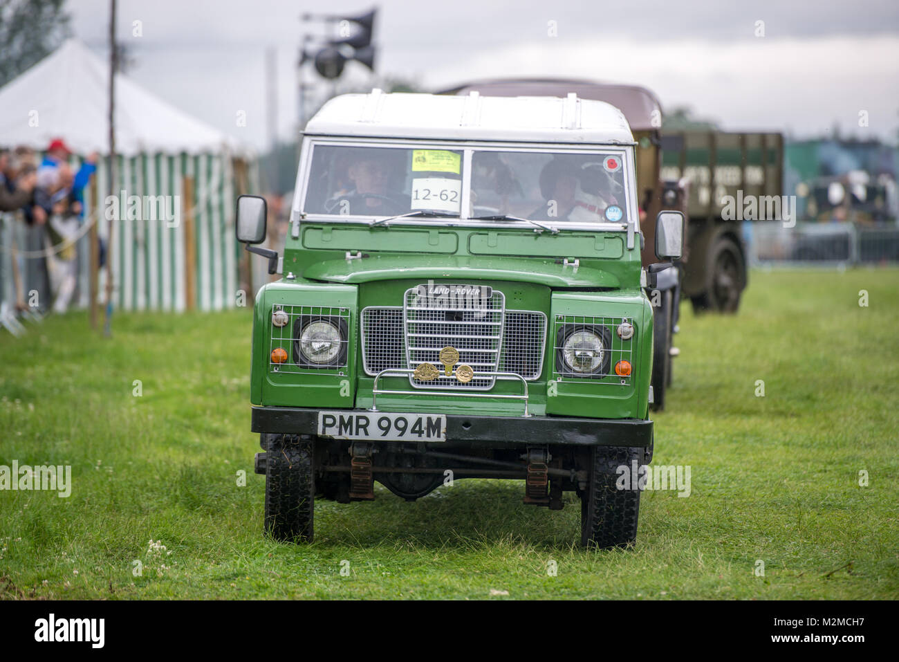 Vue avant du vintage green Land Rover roulant le long dans l'herbe, Masham, North Yorkshire, UK Banque D'Images