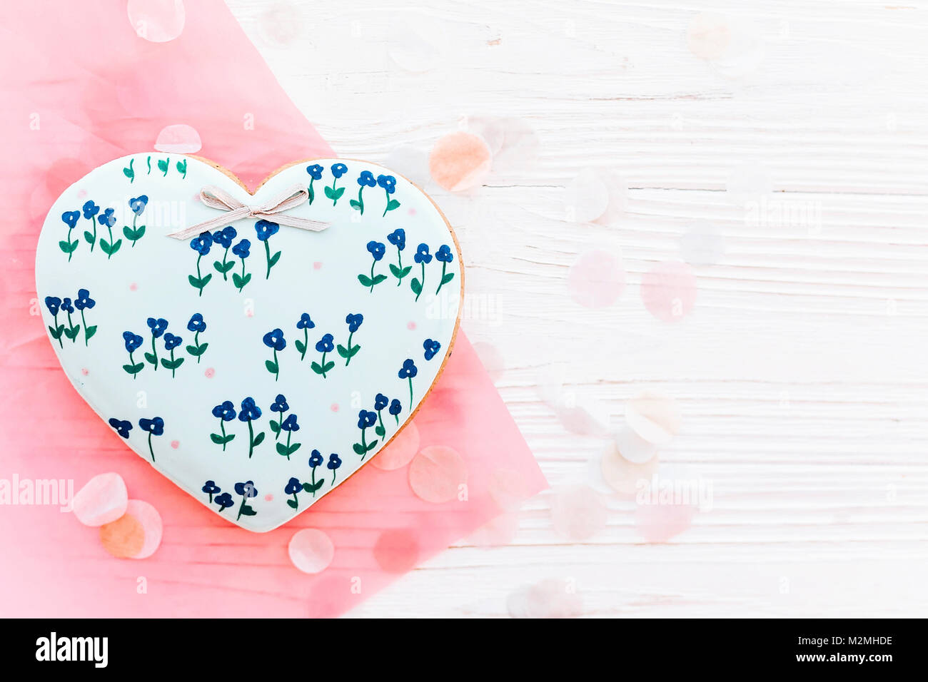 Happy mother's day Greeting card. cookie coeur à fleurs bleues sur fond blanc en bois rustique avec télévision confettis lay. espace pour texte. Heureux valen Banque D'Images